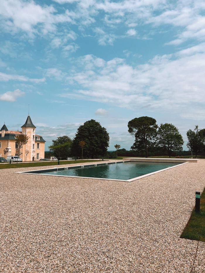 Charming outdoor pool setting beside a historic building under a clear sky.
