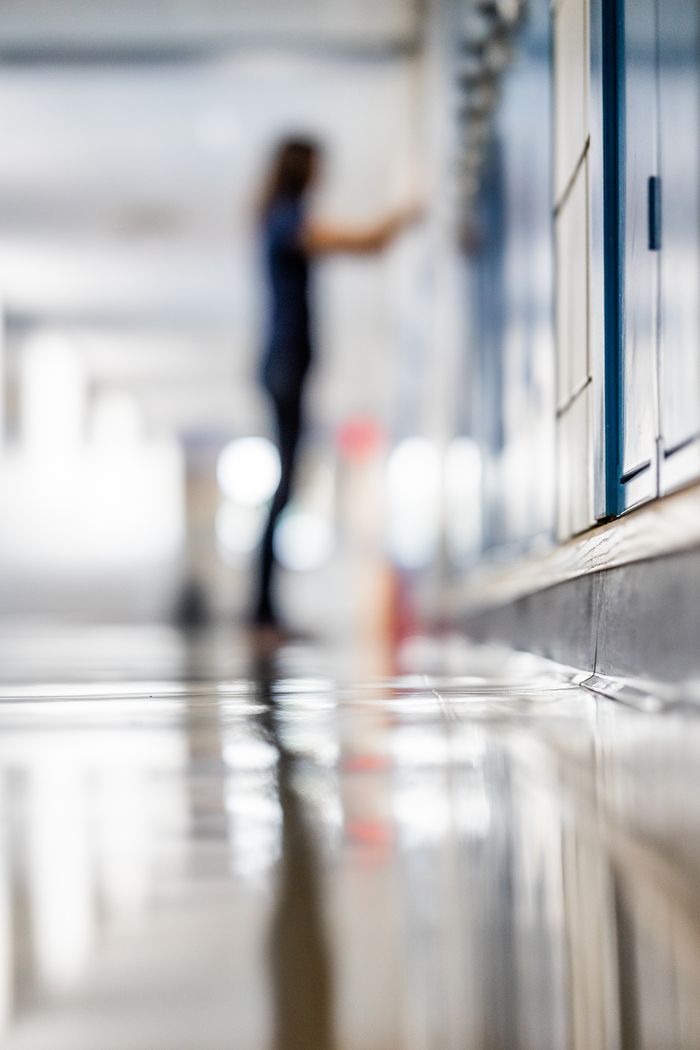 Abstract view of a school hallway with motion blur of a student by lockers.